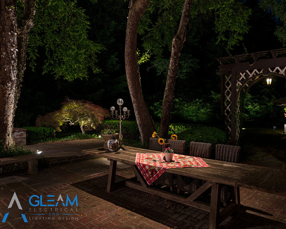 beautiful backyard picnic table with spotlight illuminating the area showcasing Gleams lighting applications