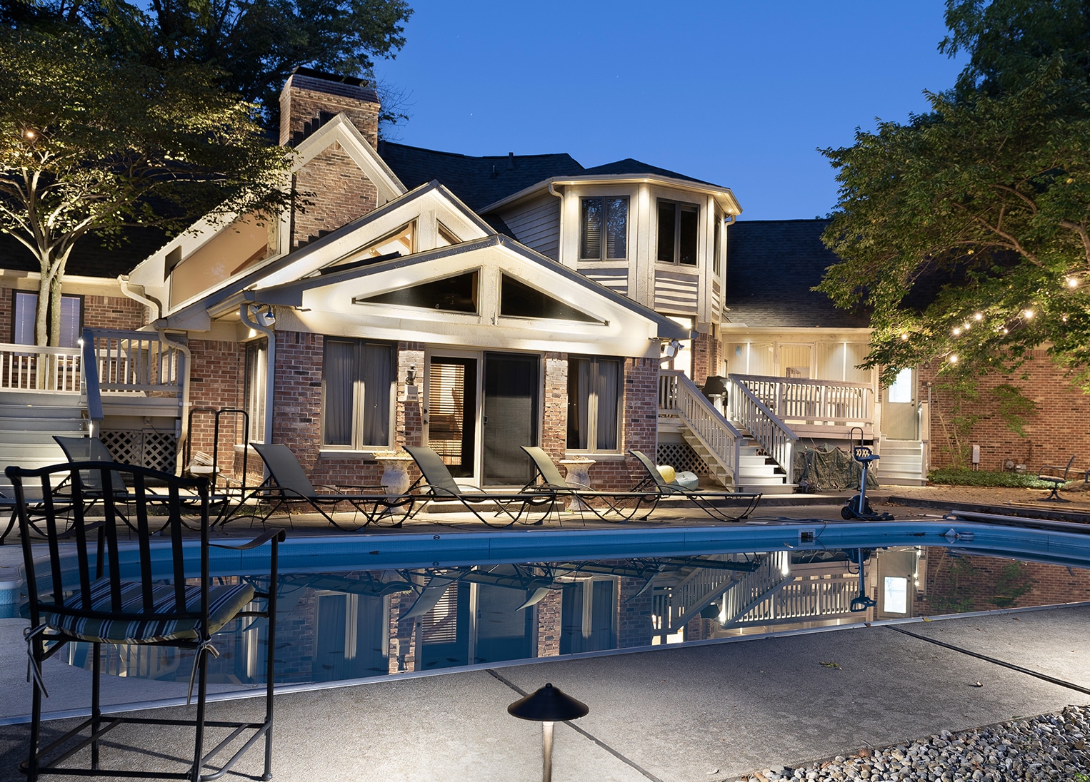 House on lake backyard with pool lighting