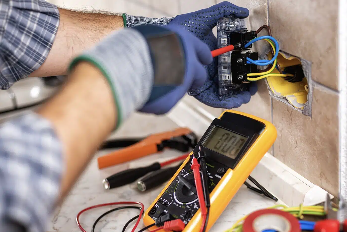 Electrician at work with safety equipment on a residential electrical system.