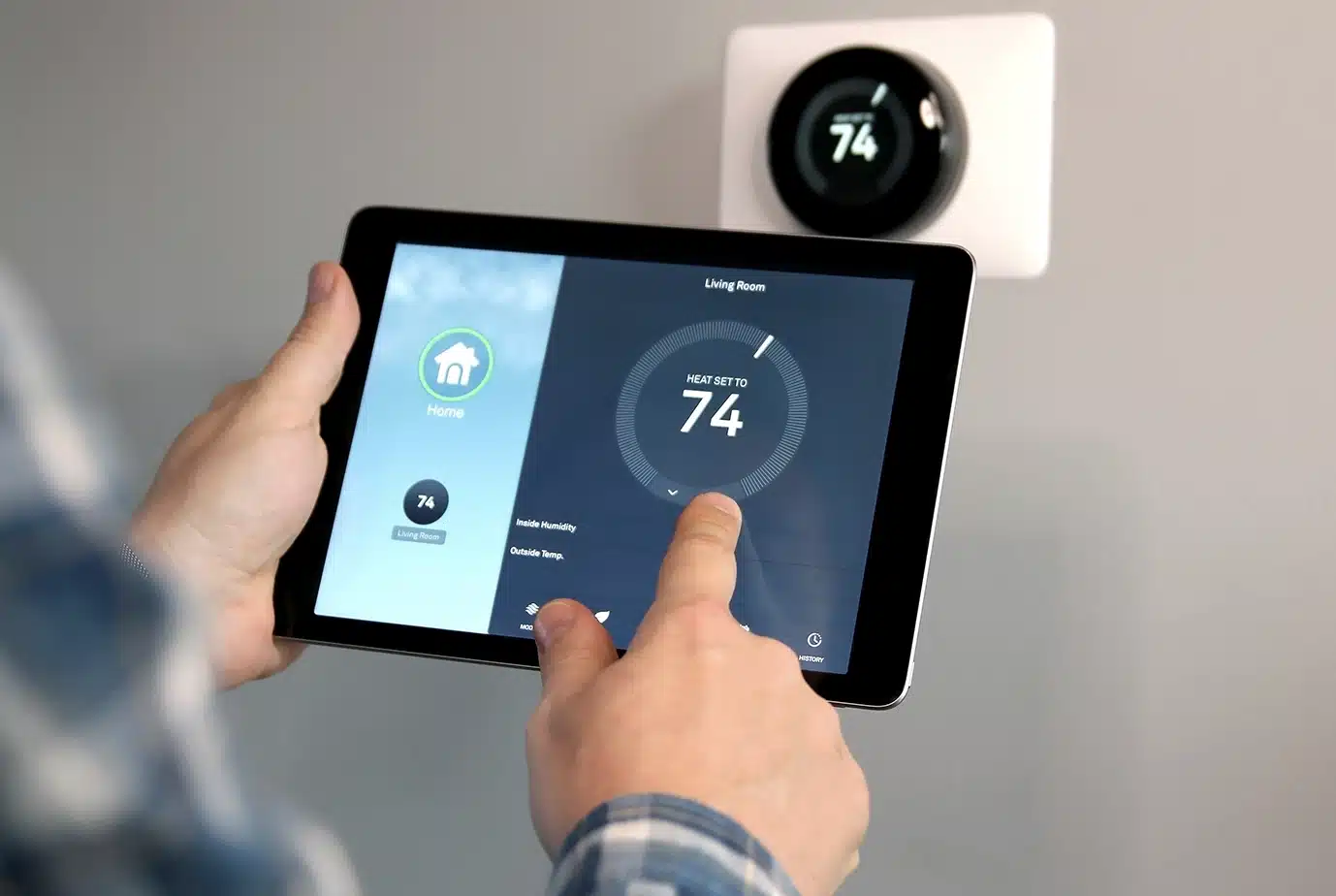 man controlling smart thermostat