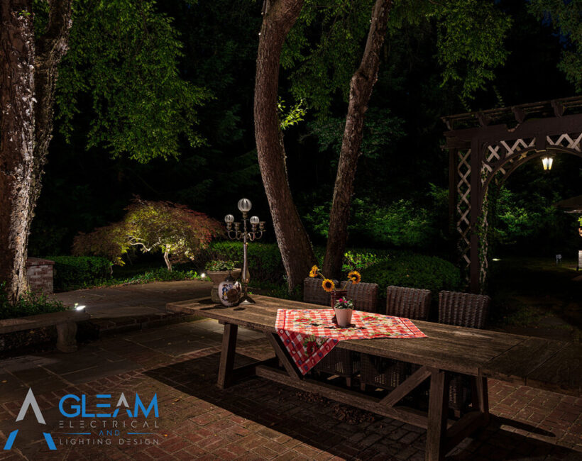beautiful backyard picnic table with spotlight illuminating the area showcasing Gleams lighting applications outdoor lighting