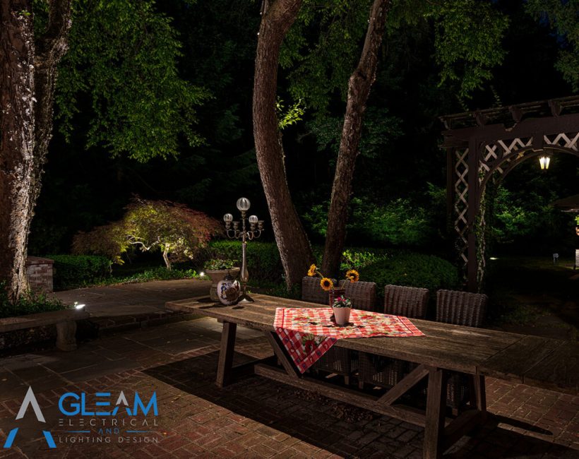 beautiful backyard picnic table with spotlight illuminating the area showcasing Gleams lighting applications outdoor lighting